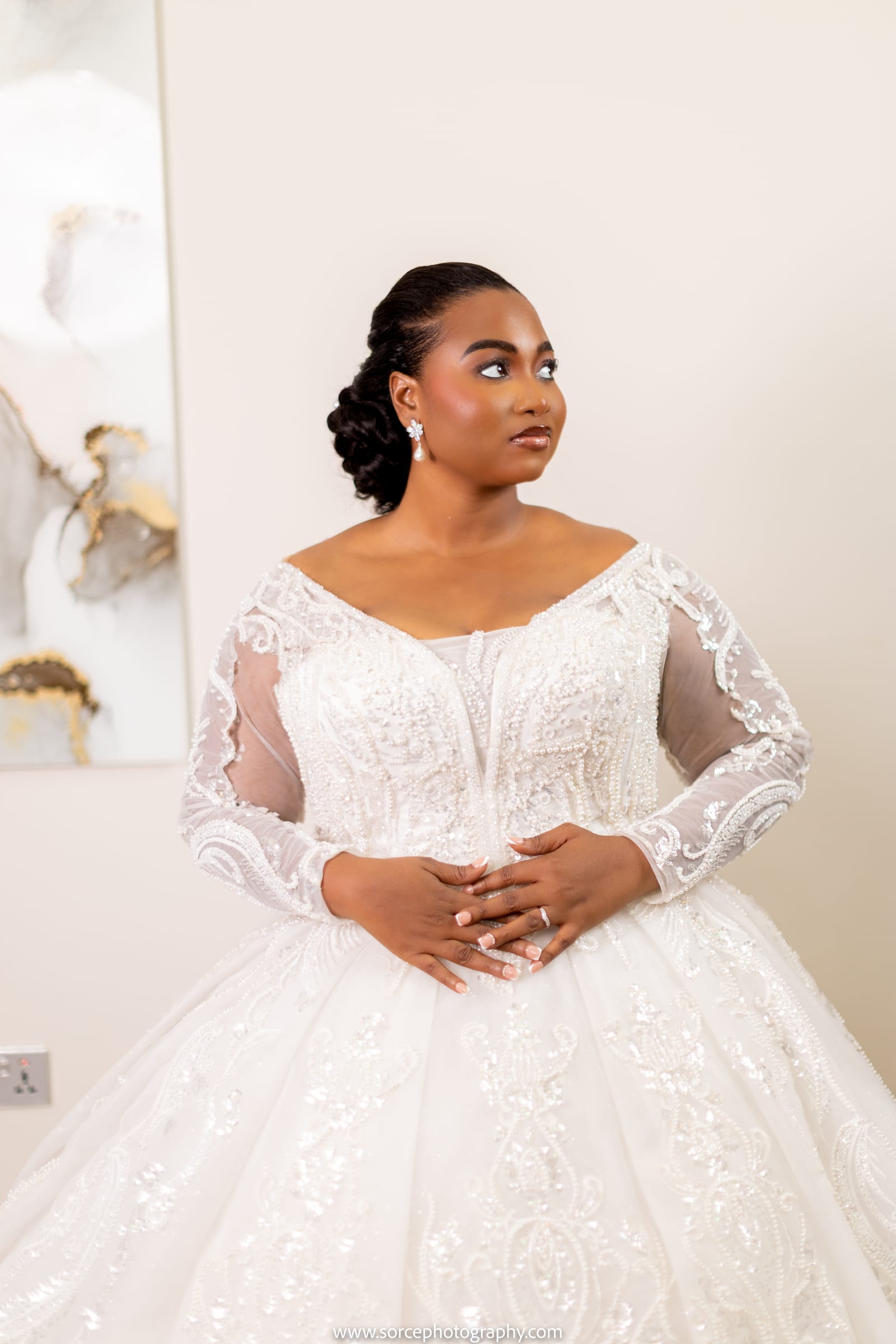 Bride in an embellished ball gown looking softly aside