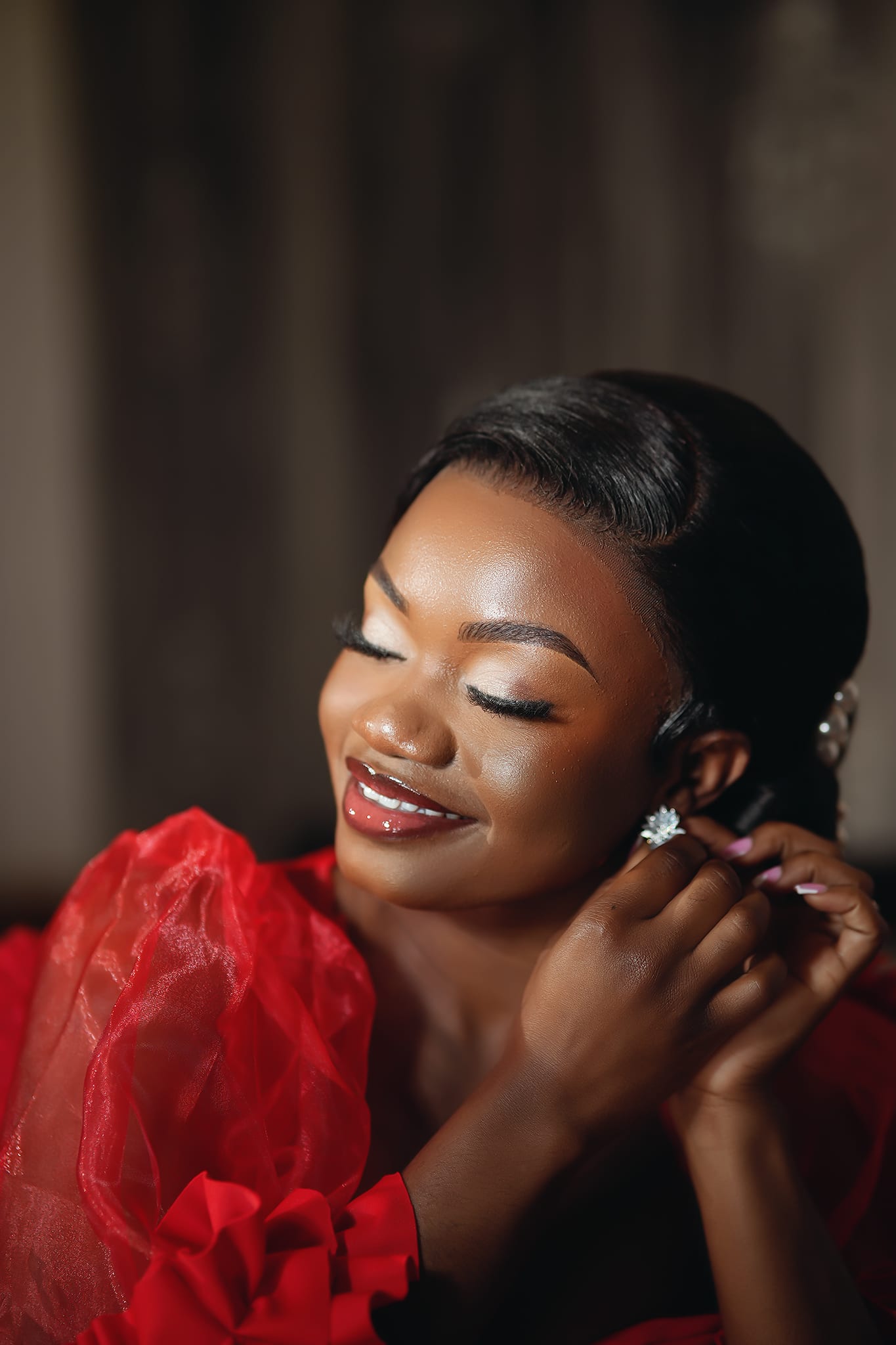Dewy skin and crystal earring moment in a red gown