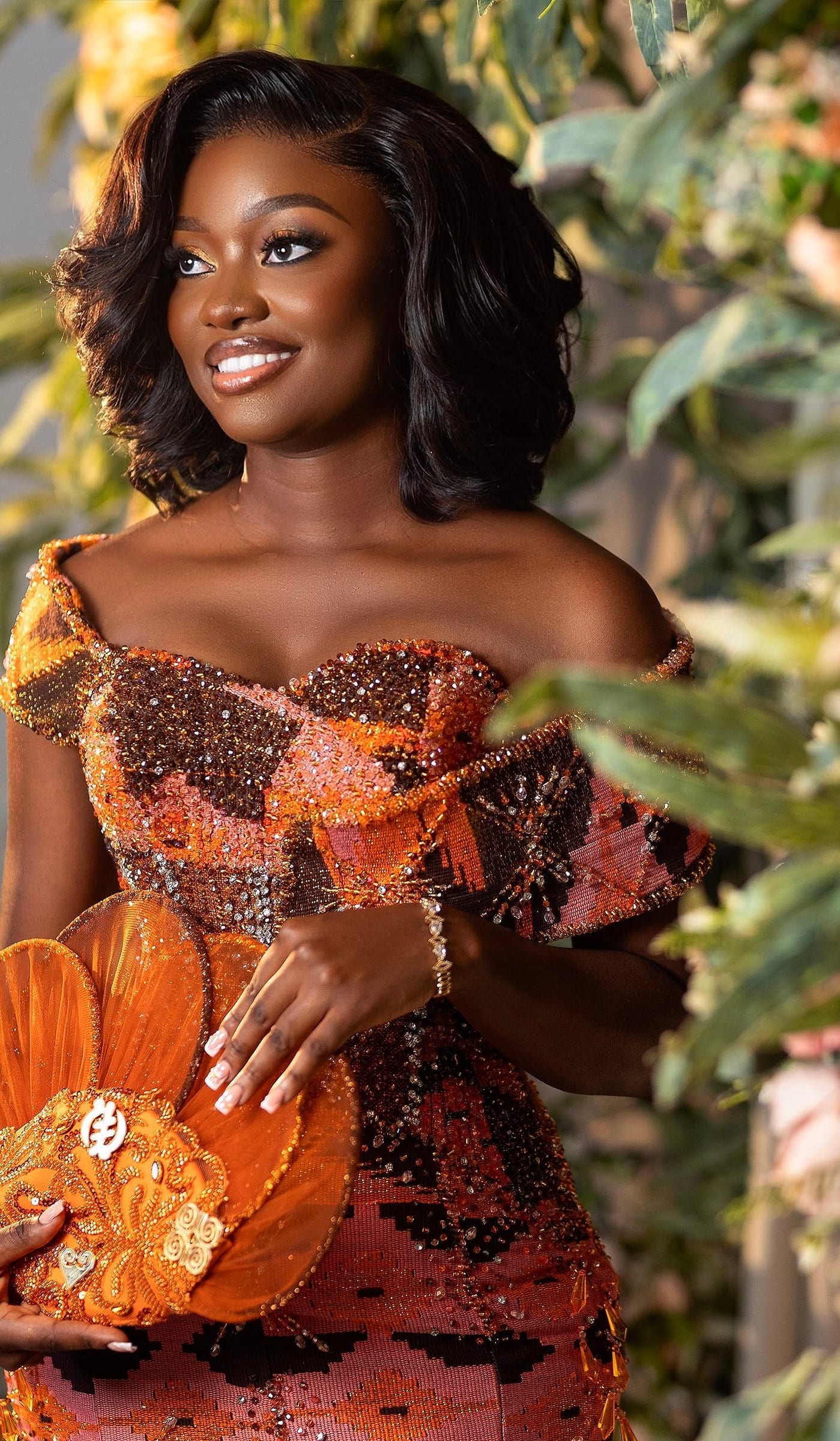 Occasion glam with gold lids and a Gye Nyame fan outdoors